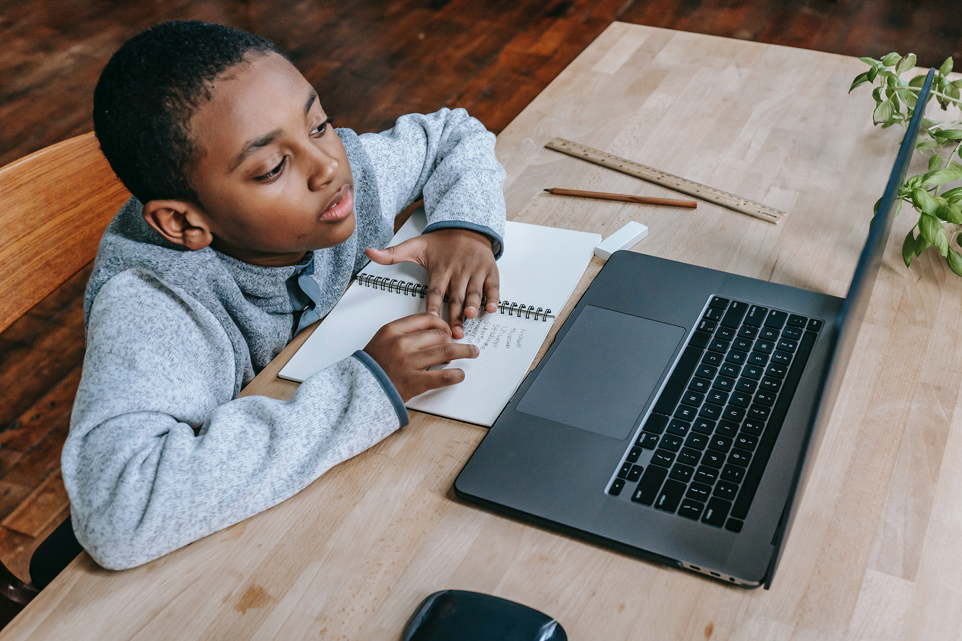 A boy at a laptop, disengaged while trying to work through his homework
