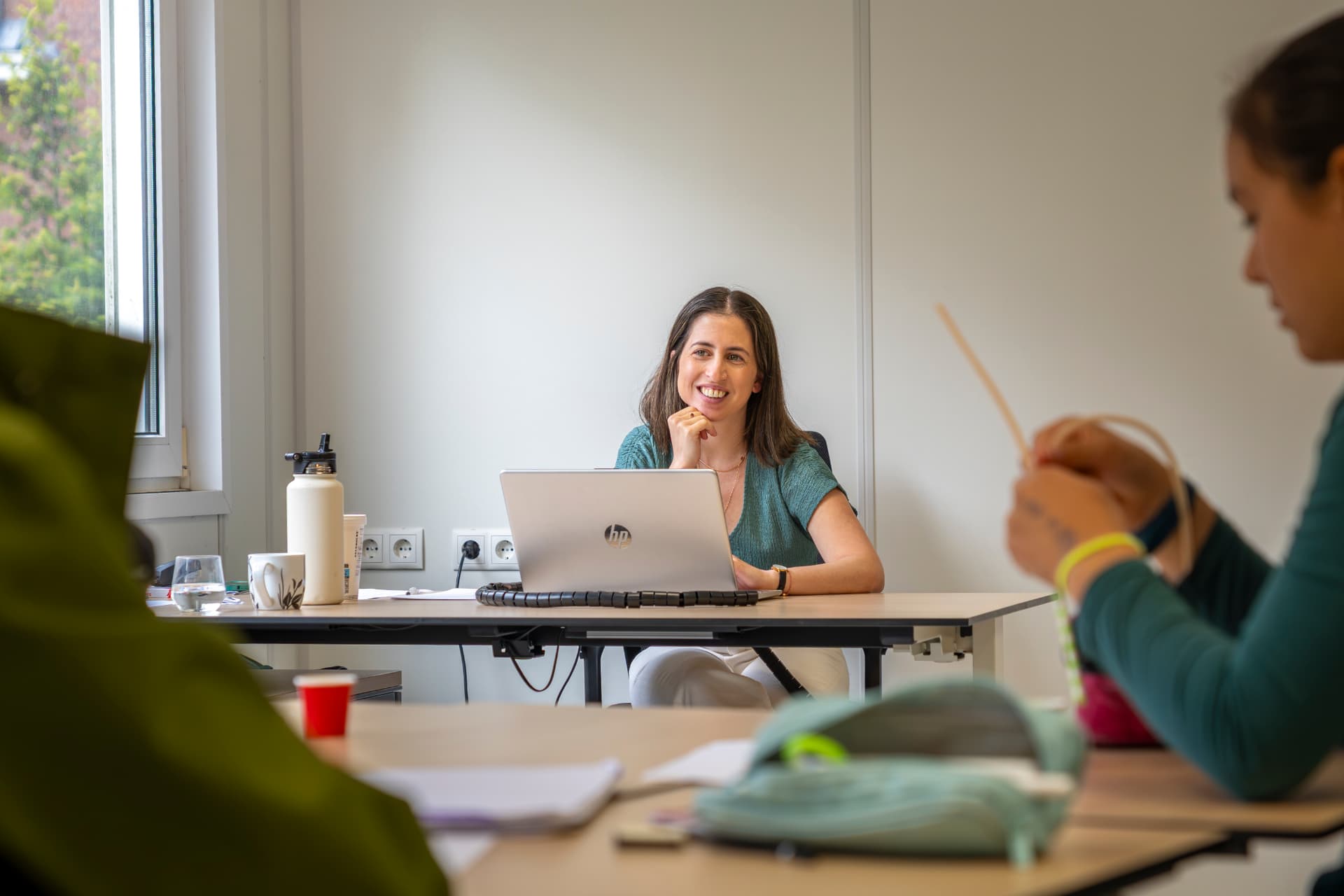 Lihi Engelsman leading a session from her laptop while teachers work at nearby tables