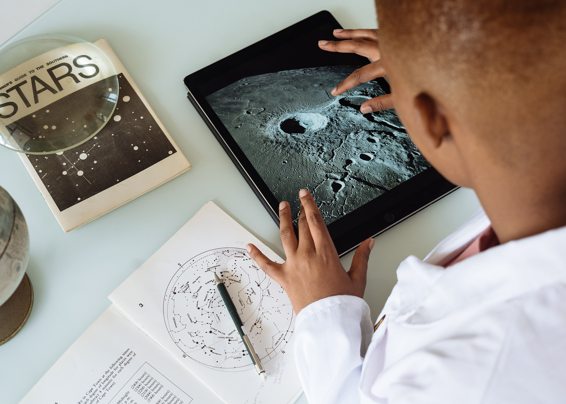 A boy looking at a tablet doing his science project